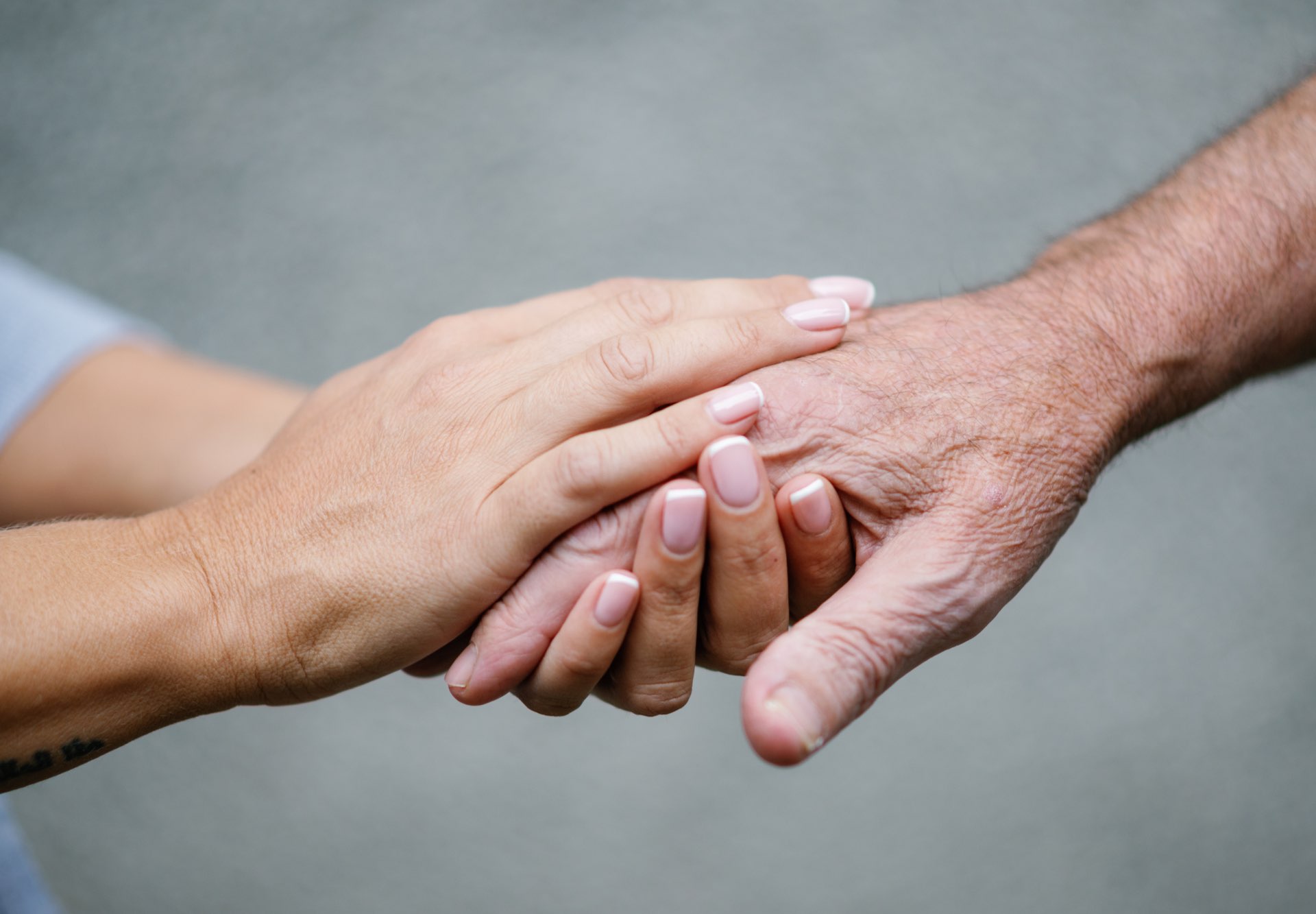 Hands being held gently, older father and daughter