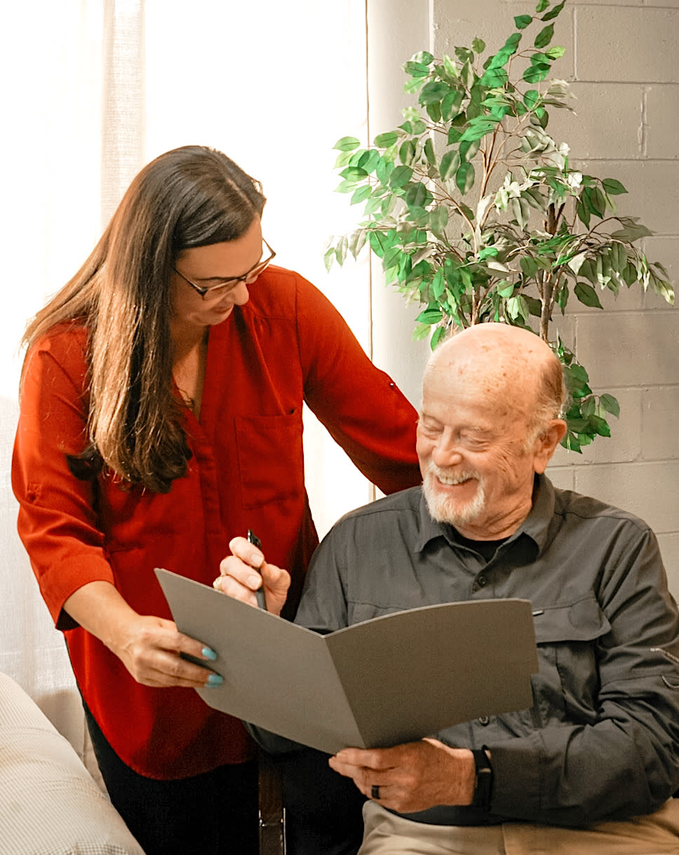 Cheyanne and a client, smiling and signing a document